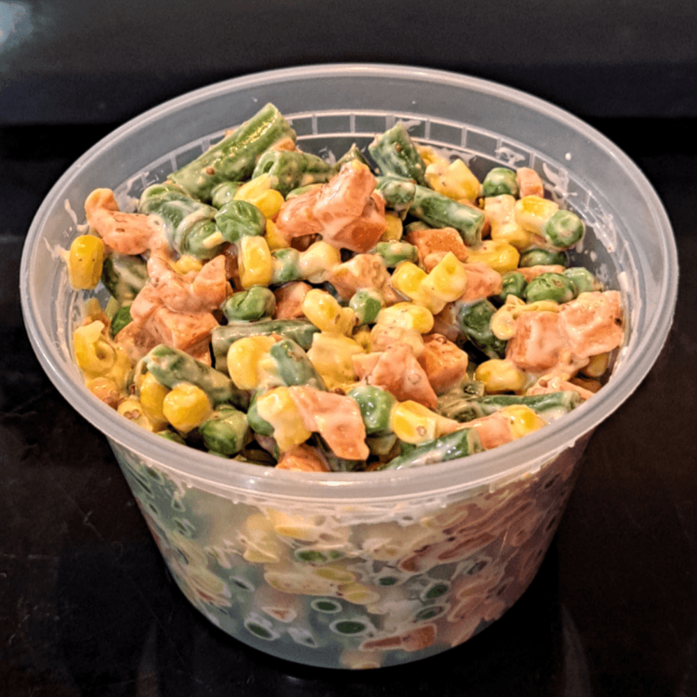 A pint plastic deli tub full of Salad Russe a la JM